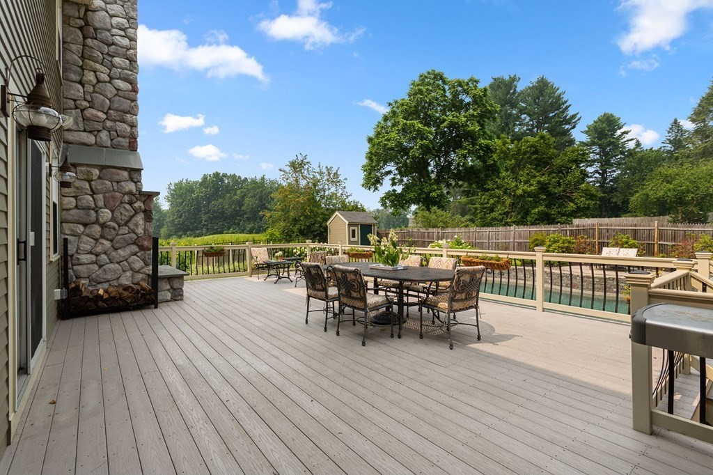 44 Old Ayer Road Groton, MA 01450 - Photo 35 of 41 a view of a roof deck with table and chairs with wooden floor and fence