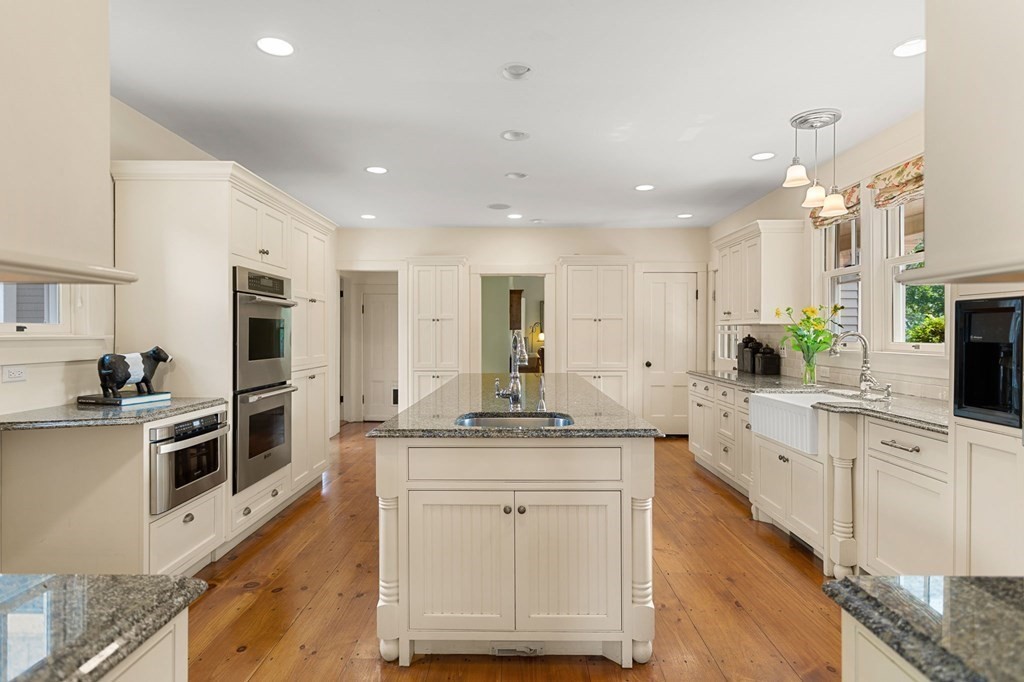 44 Old Ayer Road Groton, MA 01450 - Photo 5 of 41 a large white kitchen with stainless steel appliances granite countertop a stove and a sink