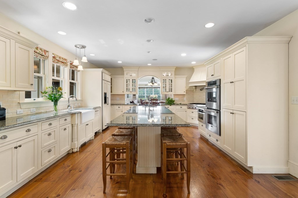 44 Old Ayer Road Groton, MA 01450 - Photo 6 of 41 a large kitchen with kitchen island a large counter top space a sink stainless steel appliances and cabinets