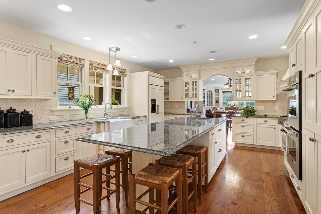 44 Old Ayer Road Groton, MA 01450 - Photo 7 of 41 a large white kitchen with kitchen island granite countertop lots of white cabinets stainless steel appliances and a island