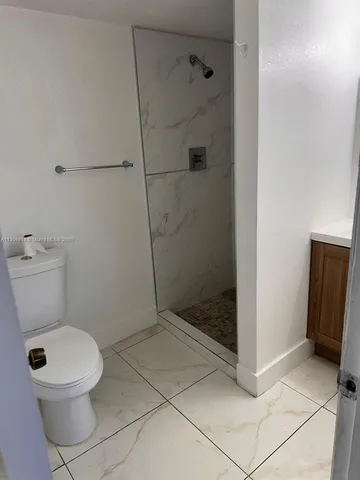 a bathroom with a toilet and a shower