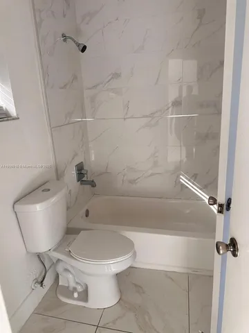 a white toilet sitting next to a bath tub