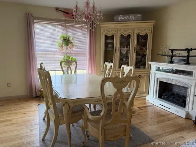 a dining room with furniture a chandelier and wooden floor