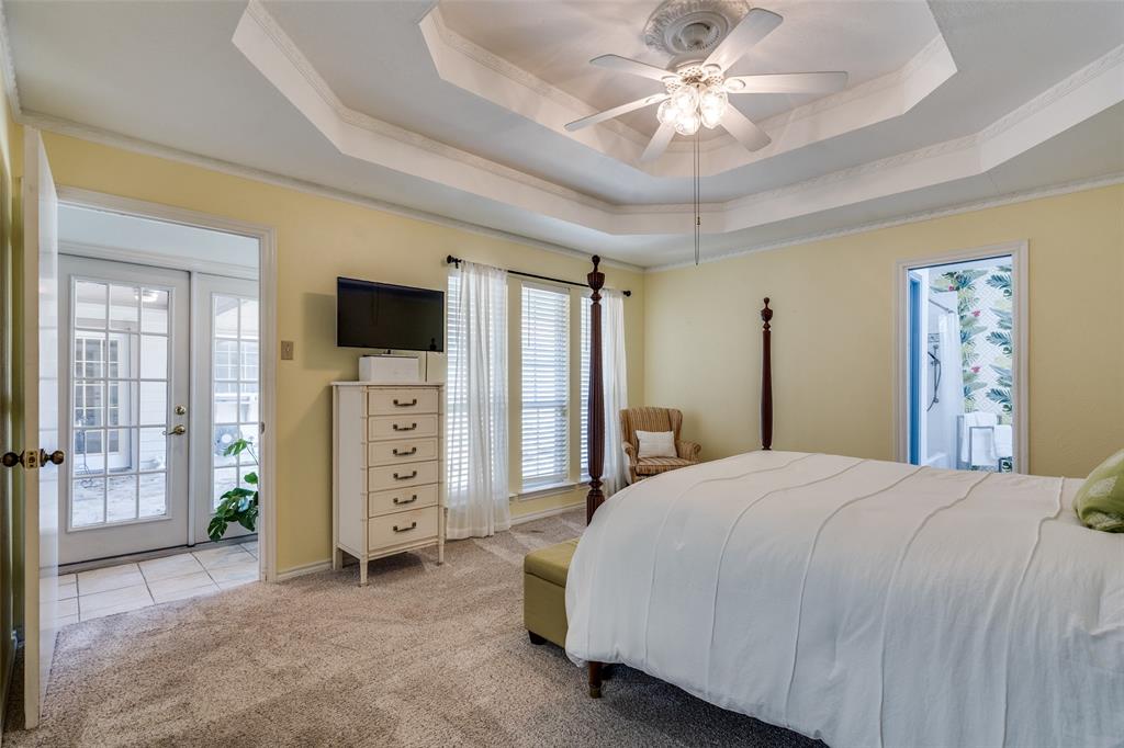 7115 Duffield Drive Dallas, TX 75248 - Photo 15 of 25 a spacious bedroom with a bed and a chandelier