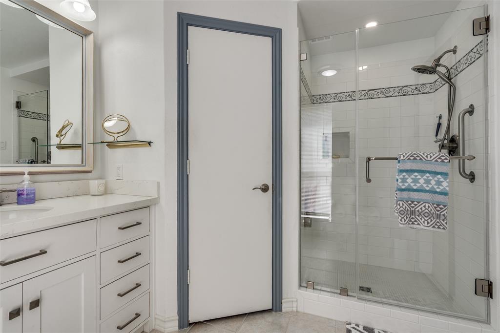 7115 Duffield Drive Dallas, TX 75248 - Photo 17 of 25 a bathroom with a shower sink and mirror