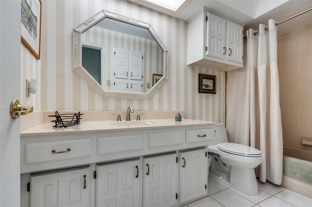 7115 Duffield Drive Dallas, TX 75248 - Photo 19 of 25 a bathroom with a sink a toilet and a mirror