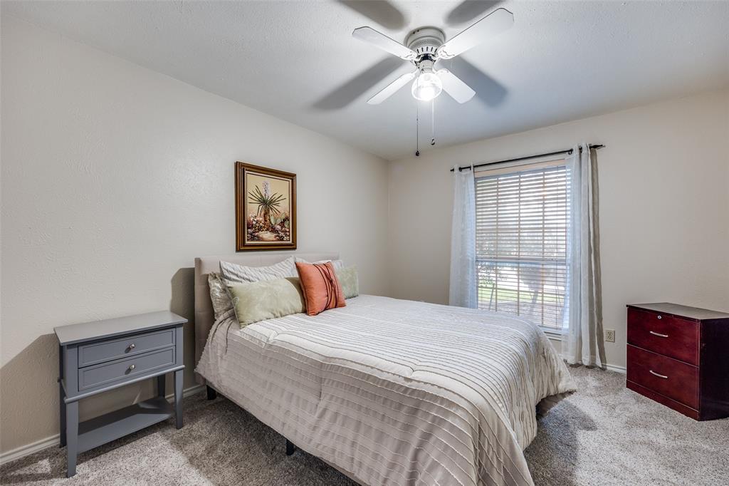7115 Duffield Drive Dallas, TX 75248 - Photo 20 of 25 a bedroom with a bed and a chandelier