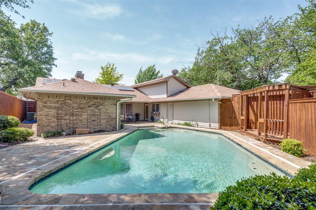 7115 Duffield Drive Dallas, TX 75248 - Photo 23 of 25 a front view of a house with a garden and trees