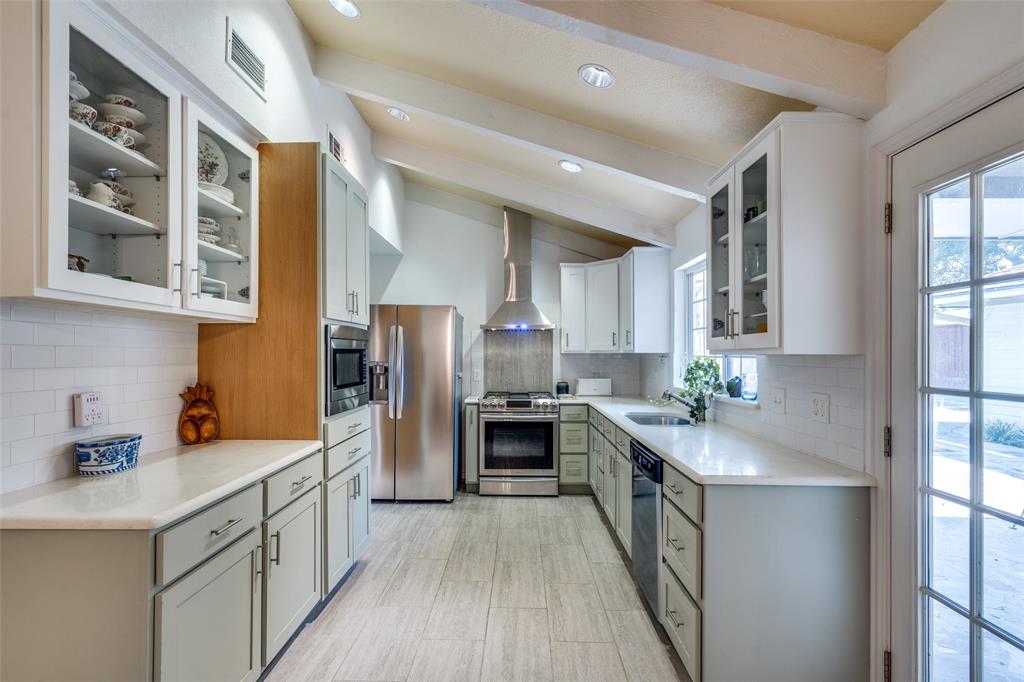 7115 Duffield Drive Dallas, TX 75248 - Photo 3 of 25 a kitchen with stainless steel appliances a stove sink refrigerator and cabinets