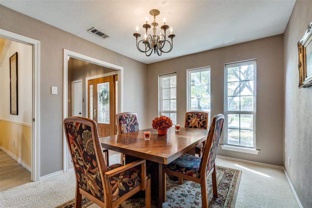 7115 Duffield Drive Dallas, TX 75248 - Photo 7 of 25 a dining room with furniture a potted plant and a chandelier