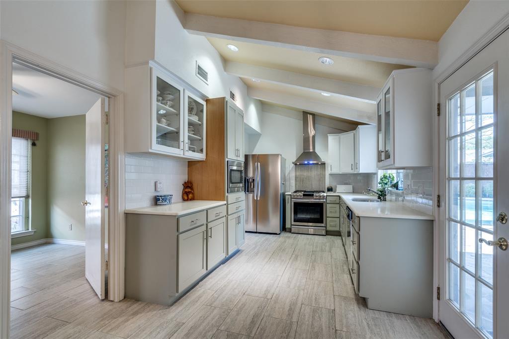 7115 Duffield Drive Dallas, TX 75248 - Photo 8 of 25 a kitchen with stainless steel appliances a stove top oven a sink a refrigerator with wooden floor and cabinets