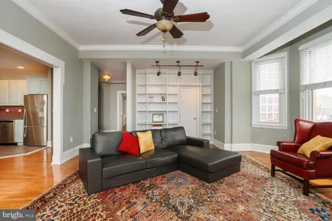 a living room with furniture wooden floor and ceiling fan