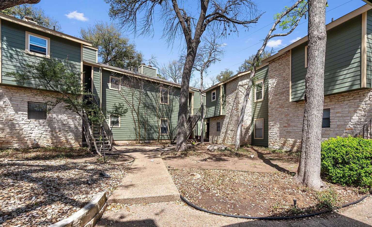11970 Jollyville Road, Unit 202 Austin, TX 78759 - Photo 23 of 25 Stone and siding exteriors define these multi-level residences nestled amidst mature trees.