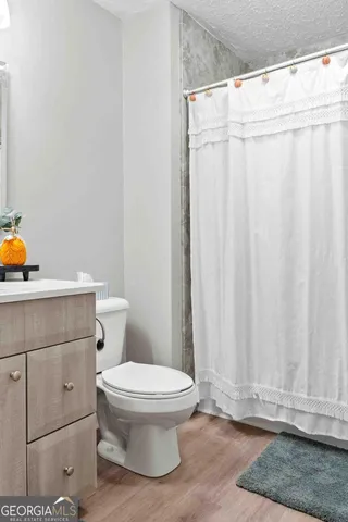 a white toilet sitting next to a shower curtain