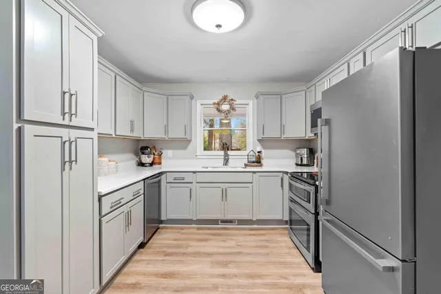 a kitchen with white cabinets and white appliances