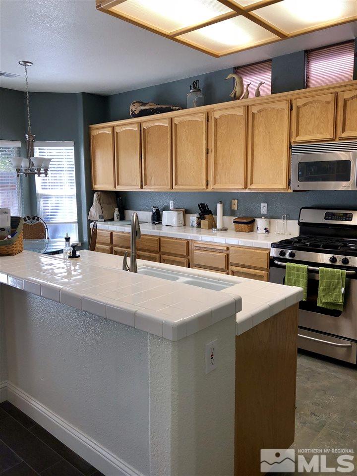 9440 Oakley Lane Reno, NV 89521 - Photo 11 of 25 a kitchen with stainless steel appliances a sink a stove and a refrigerator