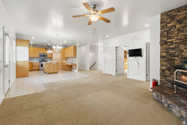 1001 Pine Valley Road Pine Valley, UT 84781 - Photo 14 of 49 Living room with light carpet, suspended lighting, ceiling fan, and a wood stove