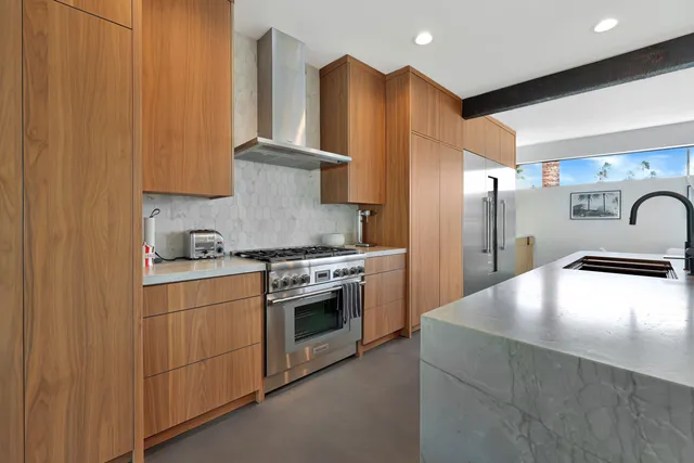 a kitchen with stainless steel appliances granite countertop a refrigerator a sink and a stove