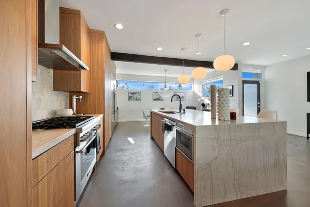 a kitchen with stainless steel appliances granite countertop a stove a sink and a refrigerator