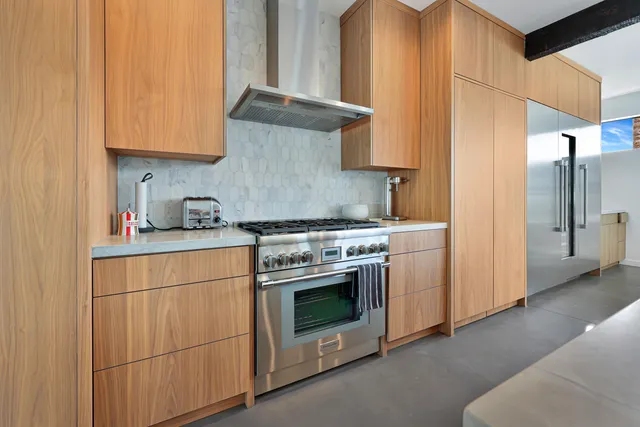 a kitchen with stainless steel appliances granite countertop a stove and a refrigerator with white cabinets