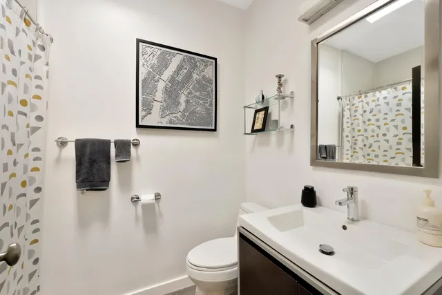 a bathroom with a sink mirror and toilet