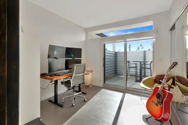 a view of a workspace with furniture and a window