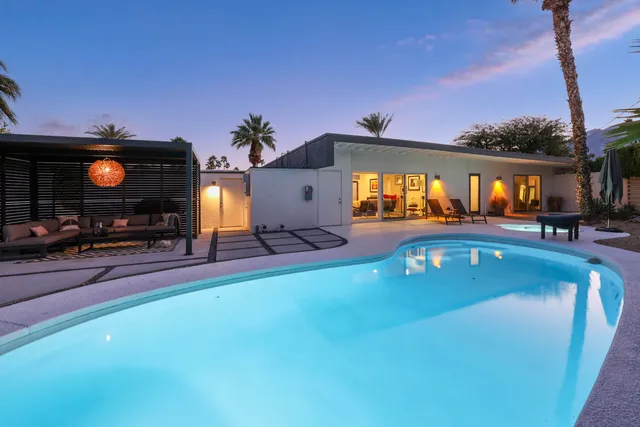 a view of a house with swimming pool and sitting area
