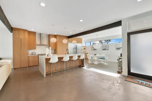 a living room with stainless steel appliances furniture and a large window
