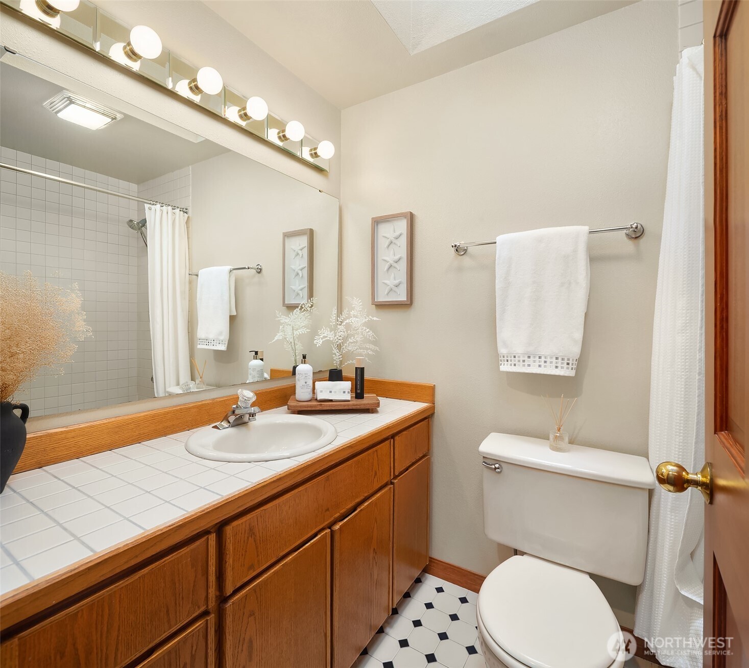 902 7th Avenue South Edmonds, WA 98020 - Photo 28 of 34 a bathroom with a toilet a sink a mirror and vanity