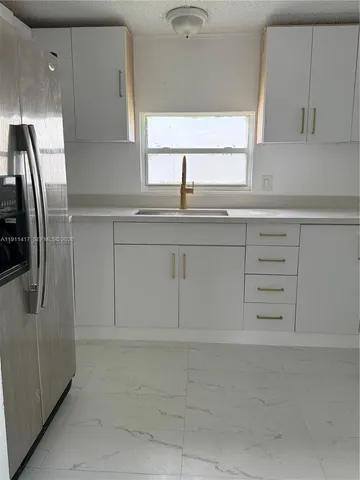 a kitchen with cabinets appliances and a window