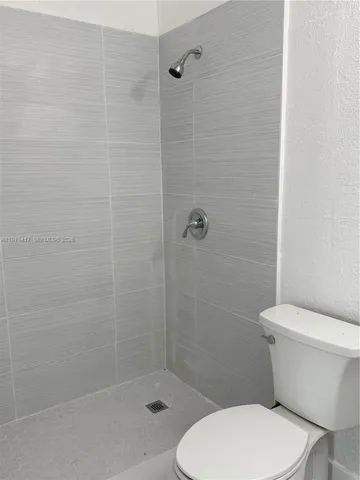 a white toilet sitting next to a bath tub