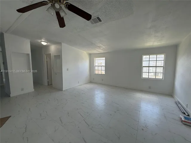 an empty room with windows and closet