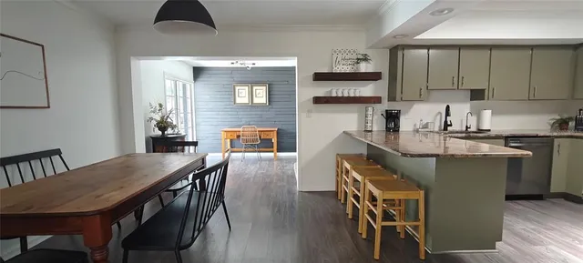 a kitchen with kitchen island granite countertop a refrigerator a stove top oven a sink and dishwasher