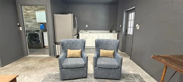 a living room with furniture a window and a flat screen tv