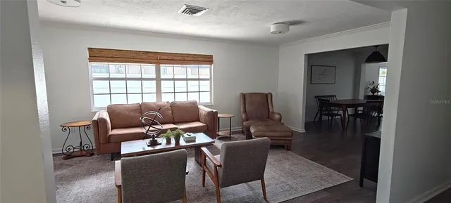 a living room with furniture and a refrigerator
