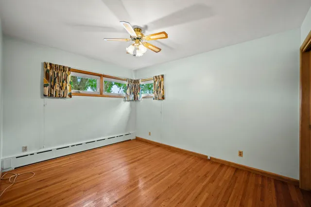 a view of empty room with wooden floor