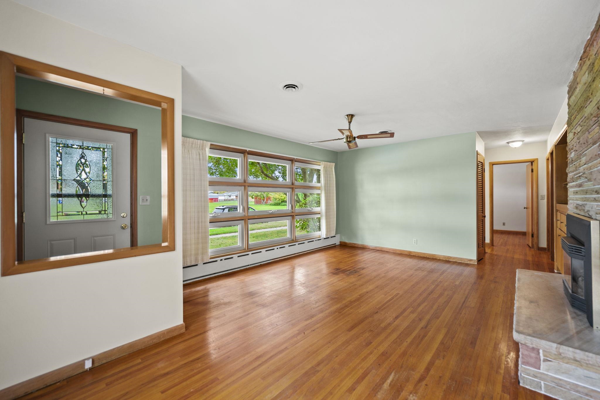 1205 7th Avenue Belvidere, IL 61008 - Photo 3 of 33 a view of an empty room with a window and wooden floor