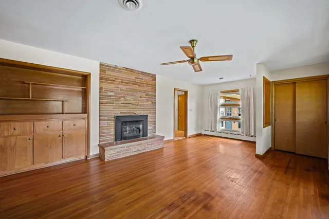 a view of a livingroom with furniture a ceiling fan and wooden floor