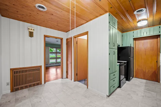 a view of a hallway with wooden walls and door