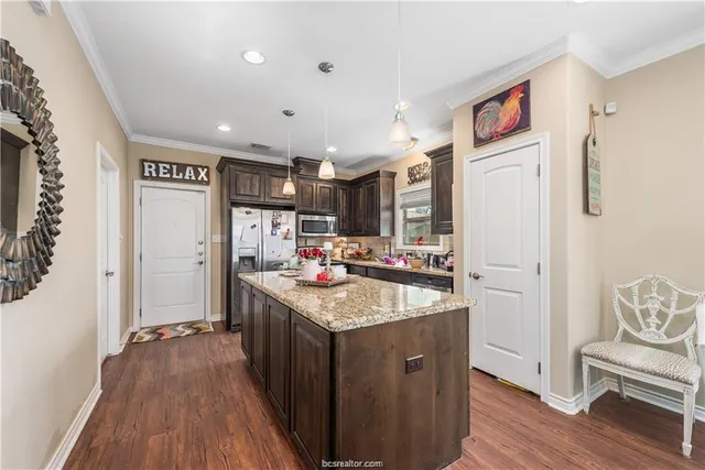 a kitchen with stainless steel appliances granite countertop a refrigerator and a sink
