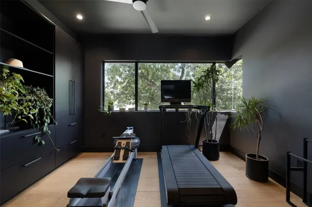 a room with gym equipment and a potted plant