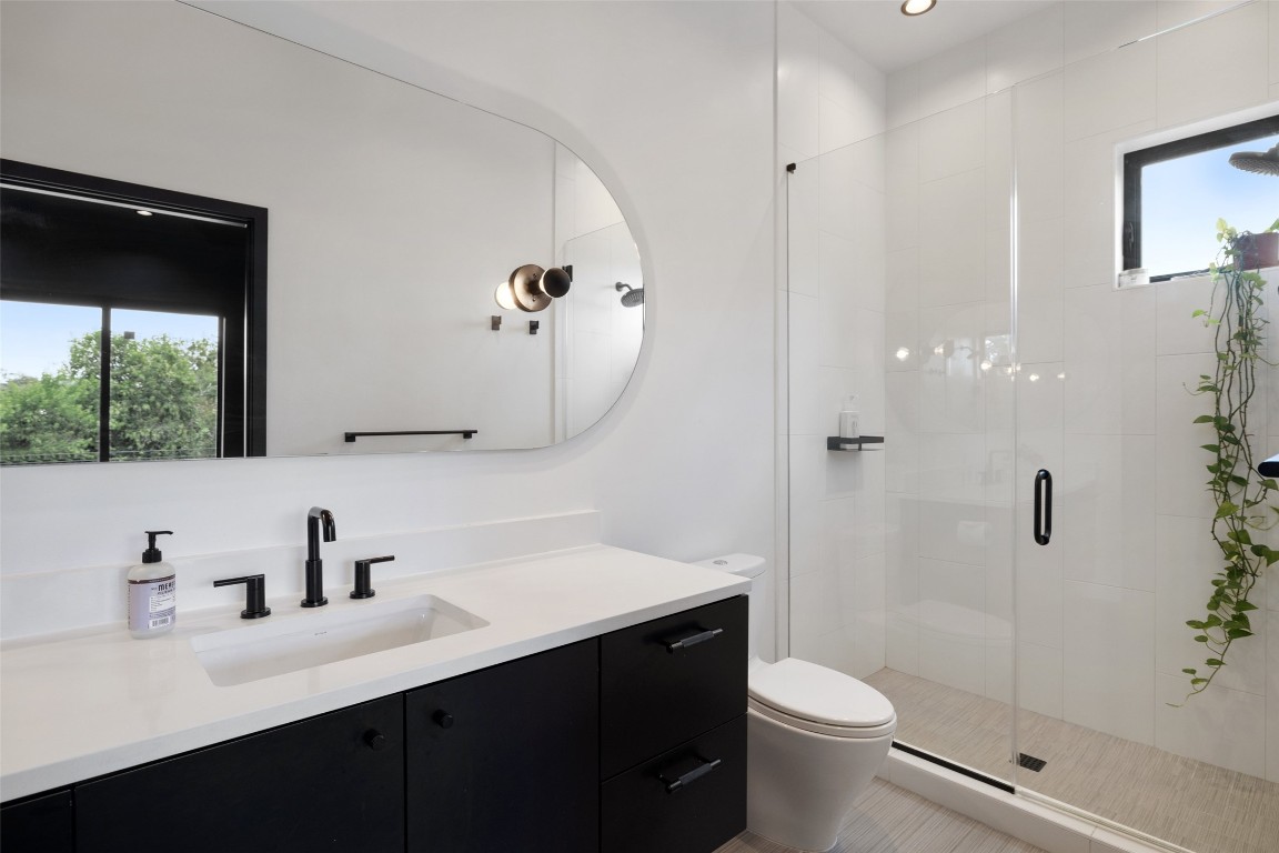 204 Westbrook Drive Austin, TX 78746 - Photo 29 of 40 a bathroom with a sink a toilet a mirror and shower
