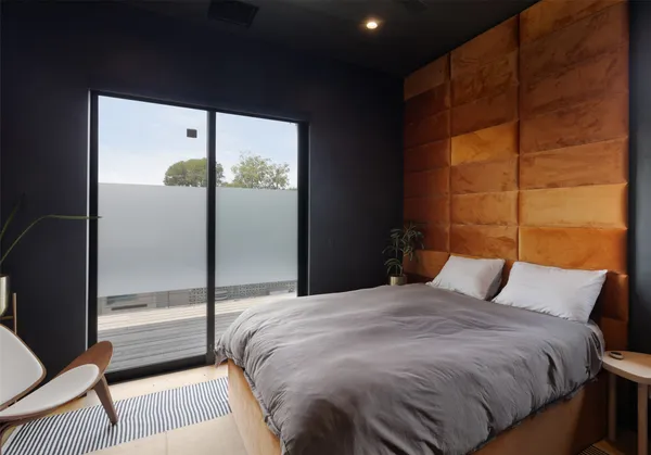 a bedroom with a bed chair and window