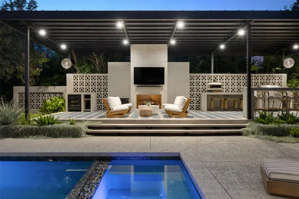 a living room with fireplace furniture and a potted plant