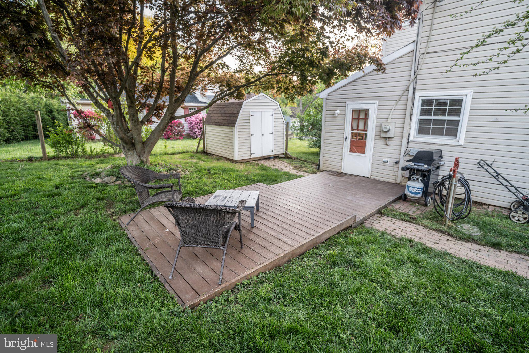 430 Pine Grove Road Bluemont, VA 20135 - Photo 27 of 58 a view of a backyard with table and chairs and a barbeque with potted plants and large trees