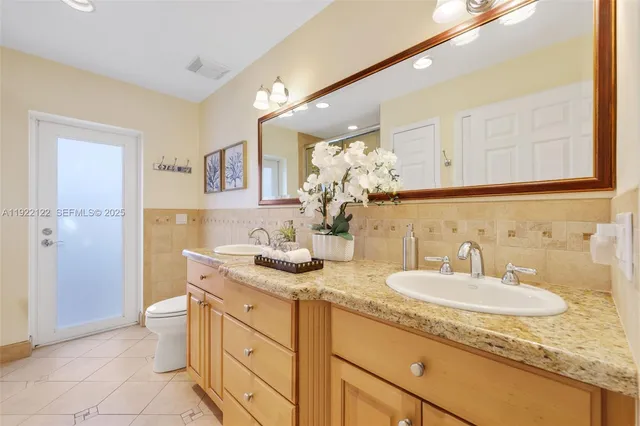 a front view of a house with a garden and trees