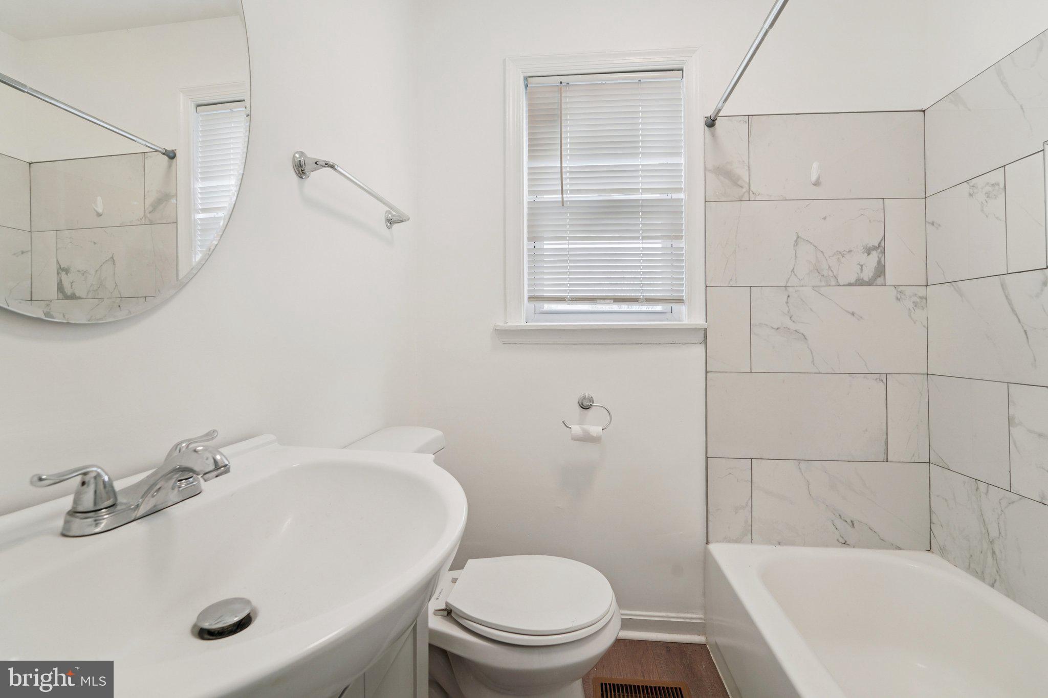 800 Stoll Street Baltimore, MD 21225 - Photo 19 of 24 a bathroom with a sink a toilet and shower
