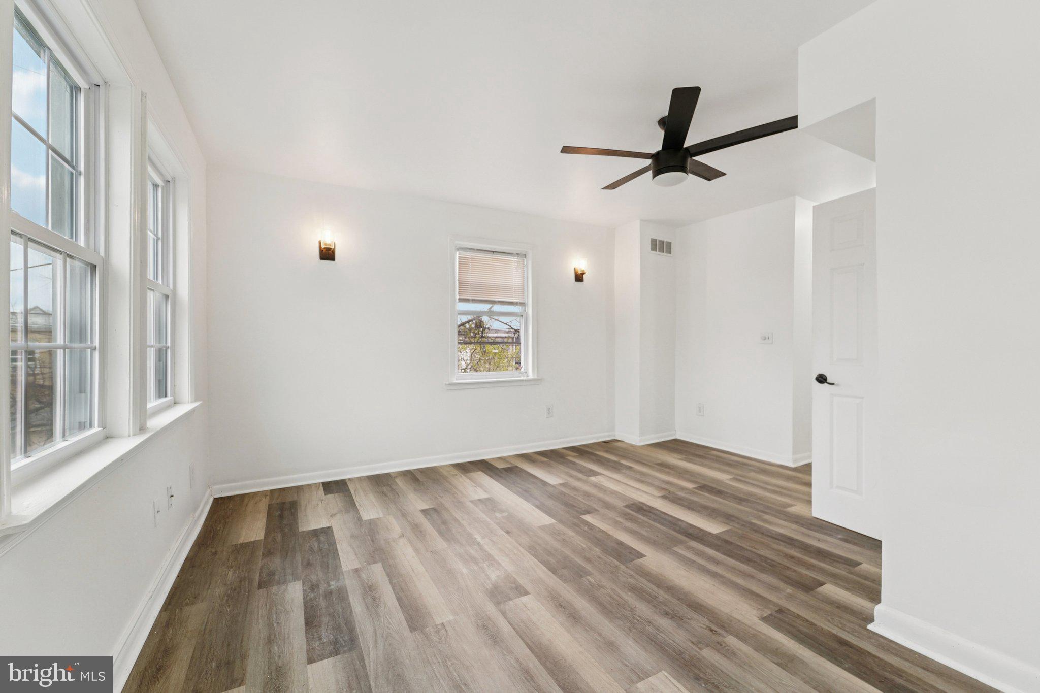 800 Stoll Street Baltimore, MD 21225 - Photo 3 of 24 wooden floor in an empty room with a window