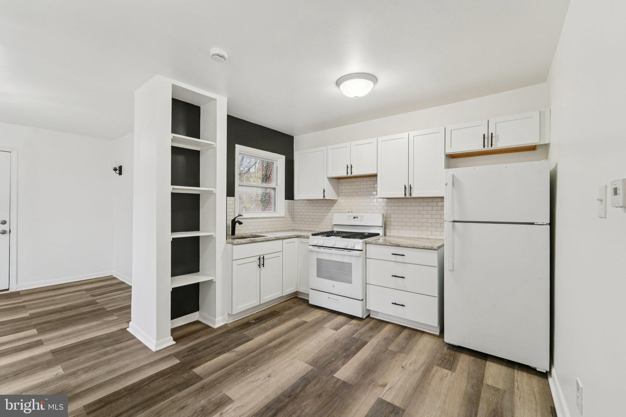 800 Stoll Street Baltimore, MD 21225 - Photo 8 of 24 a kitchen with granite countertop white cabinets and white appliances