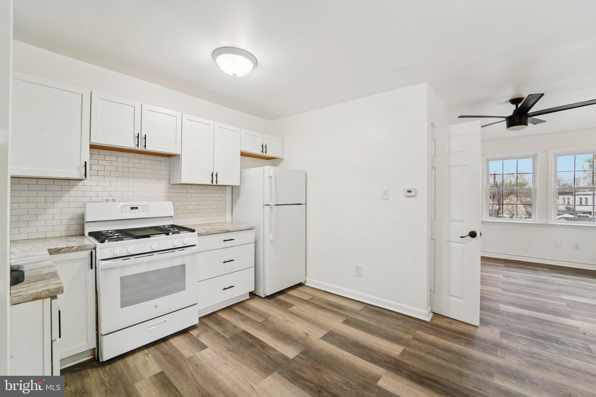 800 Stoll Street Baltimore, MD 21225 - Photo 9 of 24 a kitchen with white cabinets and white appliances